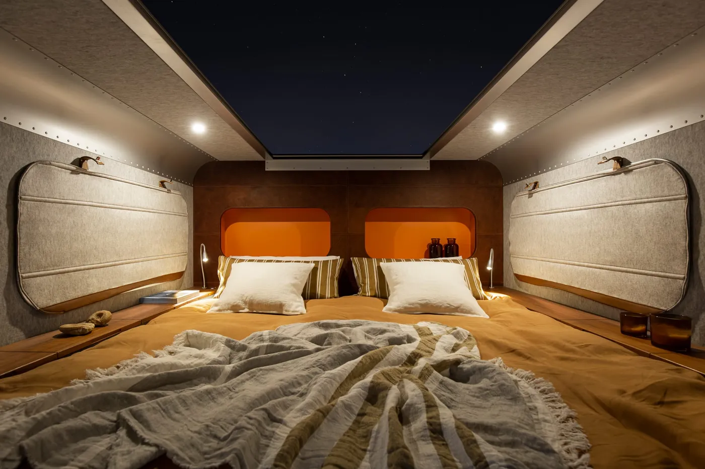 Het bed van de Lume Expedition met het dak open onder een sterrenhemel