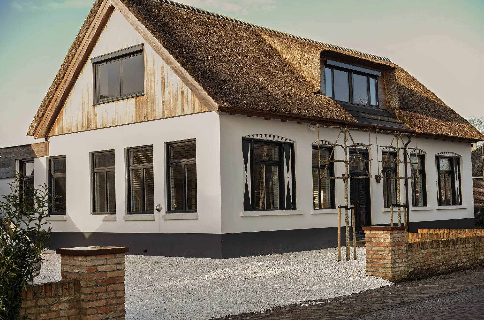 Het pand van NEST aan de Hegedyk in Luxwoude: wit gestuct huis met rieten kap