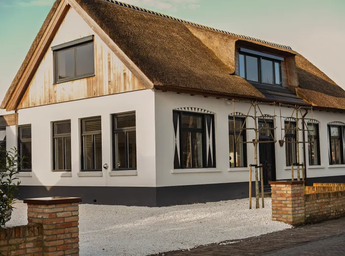 De voorgevel van het rietgedekte huis van NEST